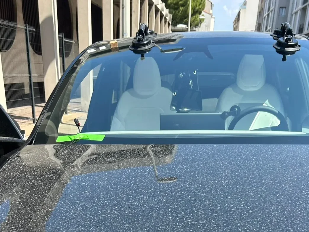 Ventouses de pose maintenant un pare-brise neuf sur une Tesla noire Ventouses de pose maintenant un pare-brise neuf sur une Tesla noire